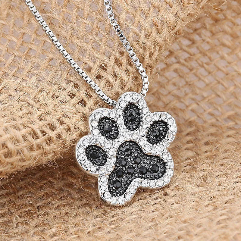 Alloy dog footprint pendant necklace with diamond-encrusted finish on light background