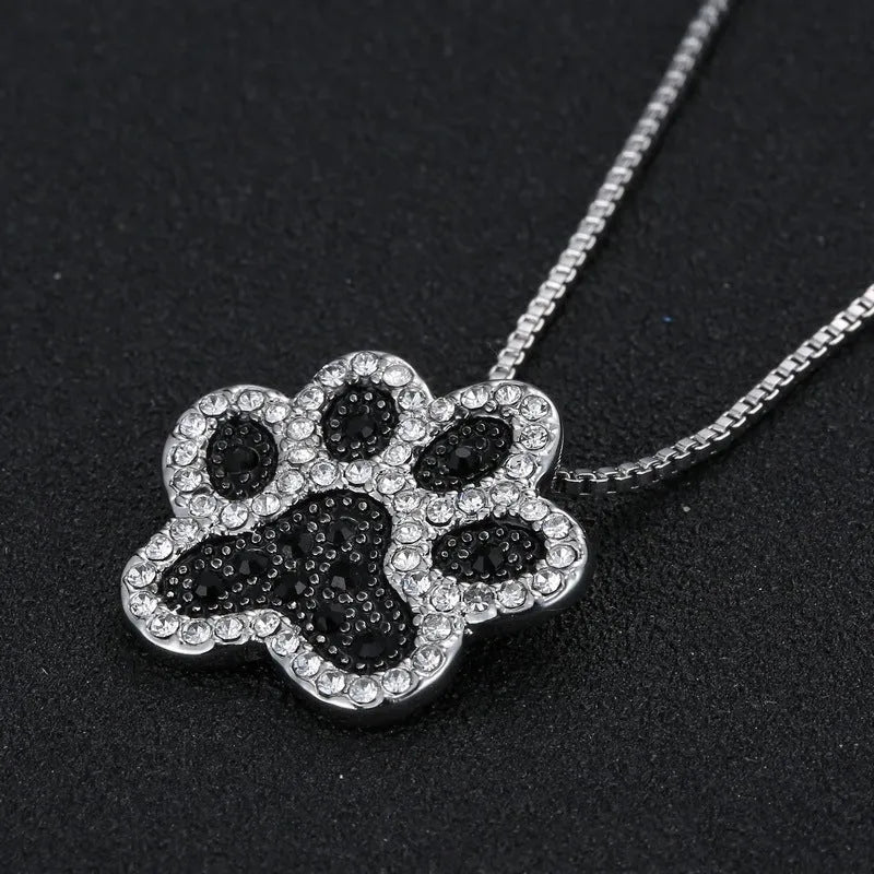 Alloy dog footprint pendant necklace with diamond-encrusted finish on light background