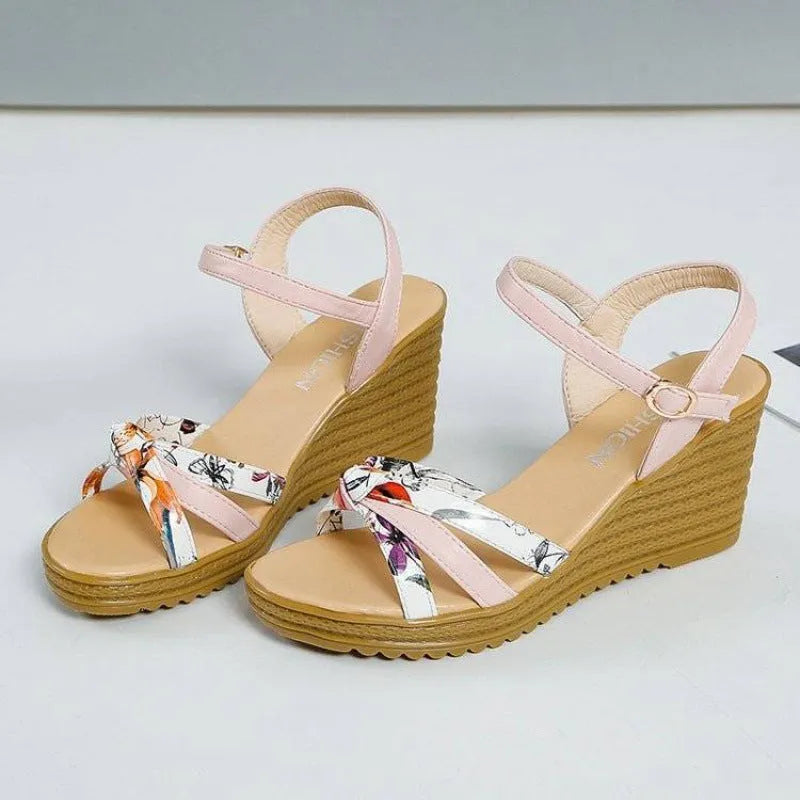 Pink women's wedge sandals with fish mouth open toe and buckle strap on a non-slip sole.