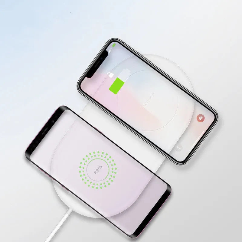 White dual wireless phone charger charging two mobile phones simultaneously