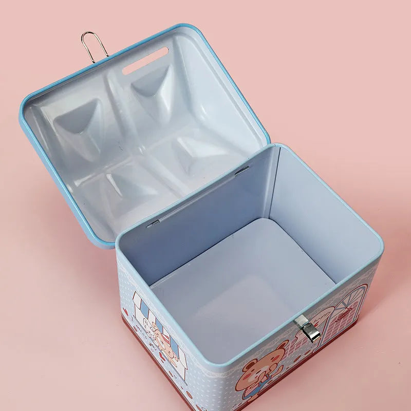 Blue house-shaped tinplate piggy bank on desktop with coin slot visible
