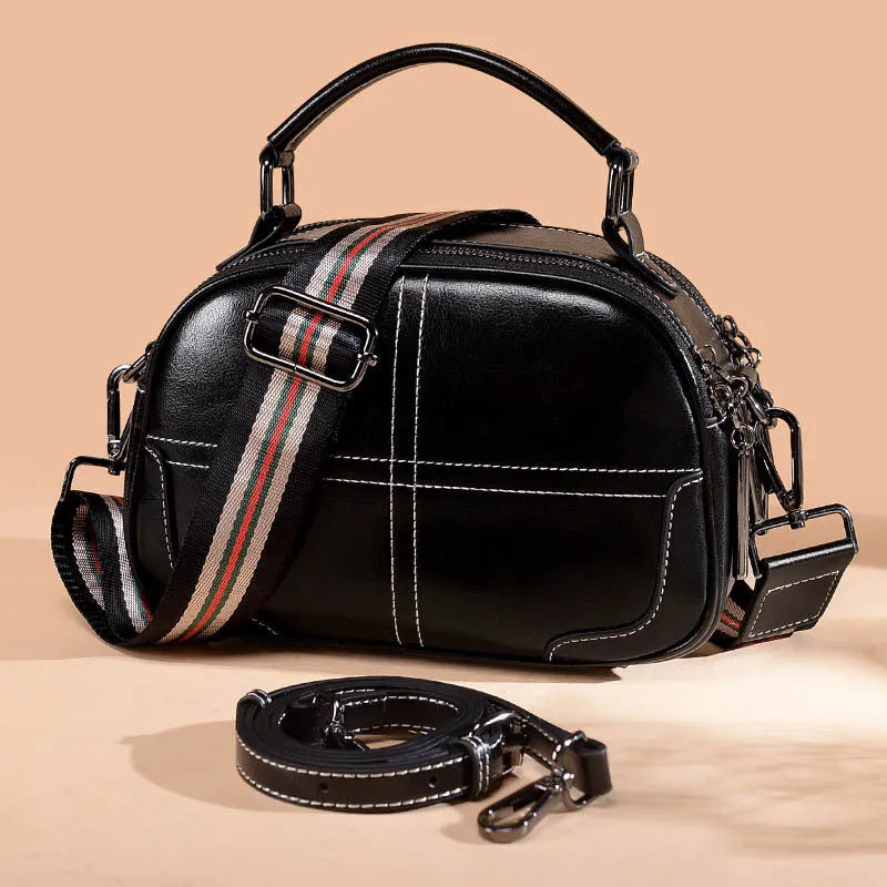 Round leather handbag with soft handles and zipper closure in wine red colour