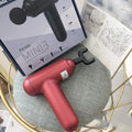Grey handheld fascia gun massager with USB charging port for muscle relaxation therapy