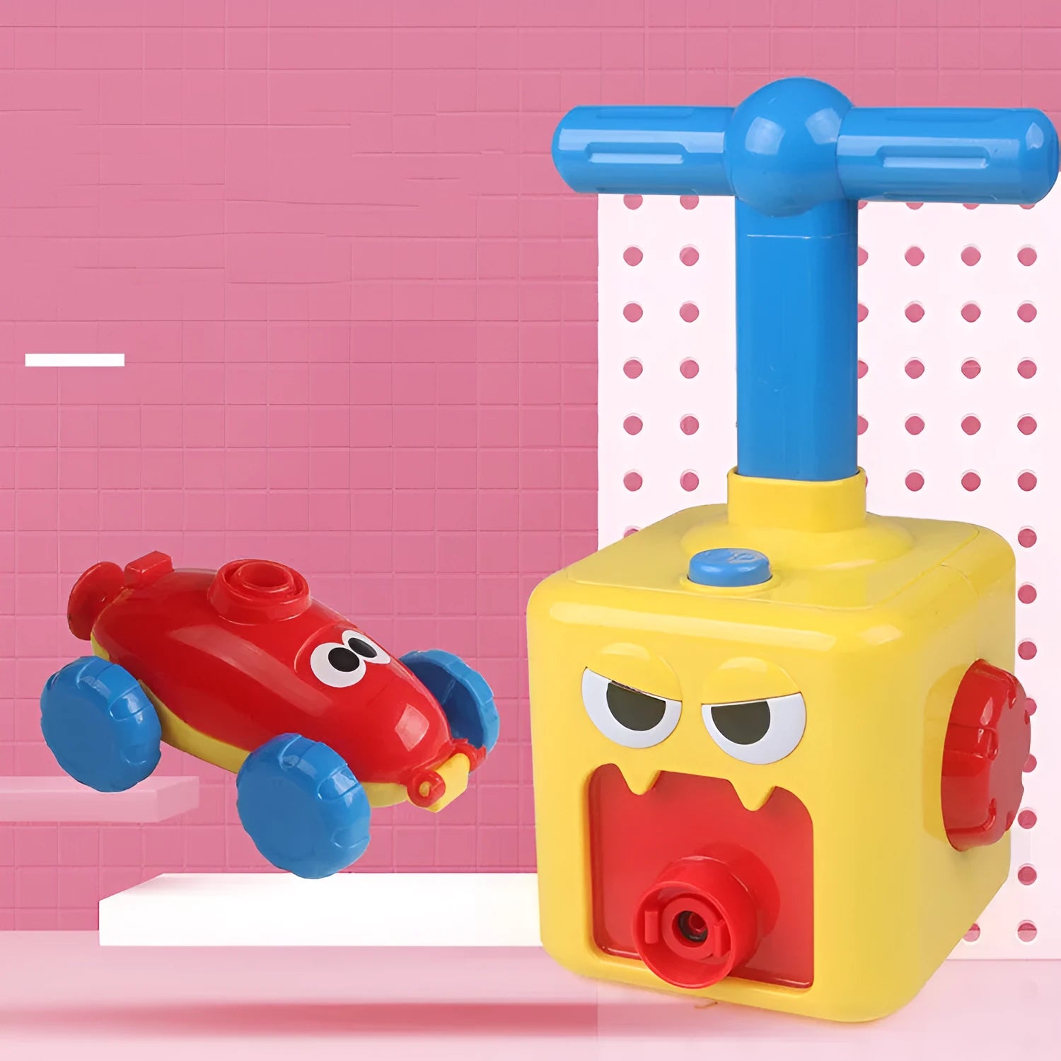 Balloon launch tower toy car with inflated balloon on a white surface