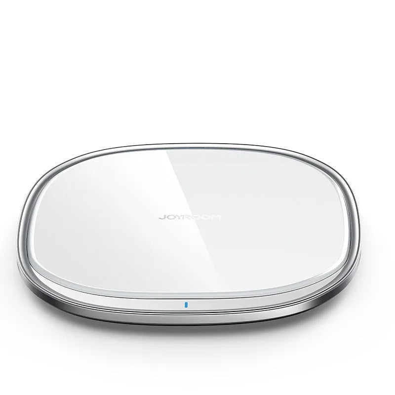 Black 15W wireless fast charger with zinc alloy frame and glass top on a wooden desk.