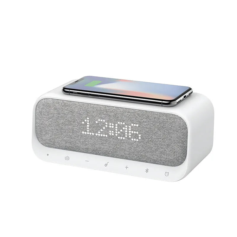 Compact pink and white Soundcore Bluetooth speaker with wireless charging pad and digital alarm clock display.