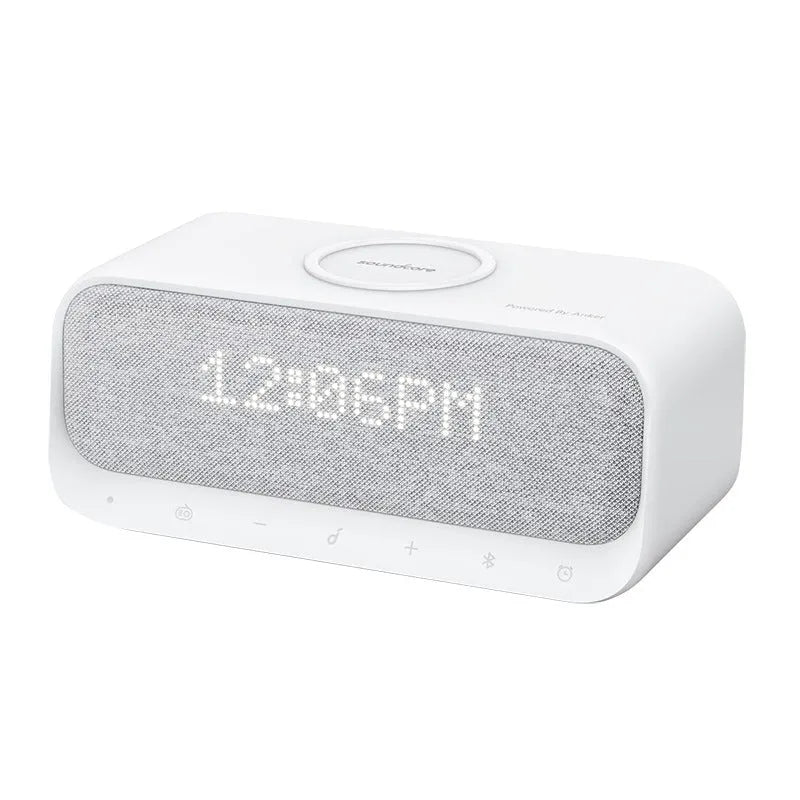 Compact pink and white Soundcore Bluetooth speaker with wireless charging pad and digital alarm clock display.