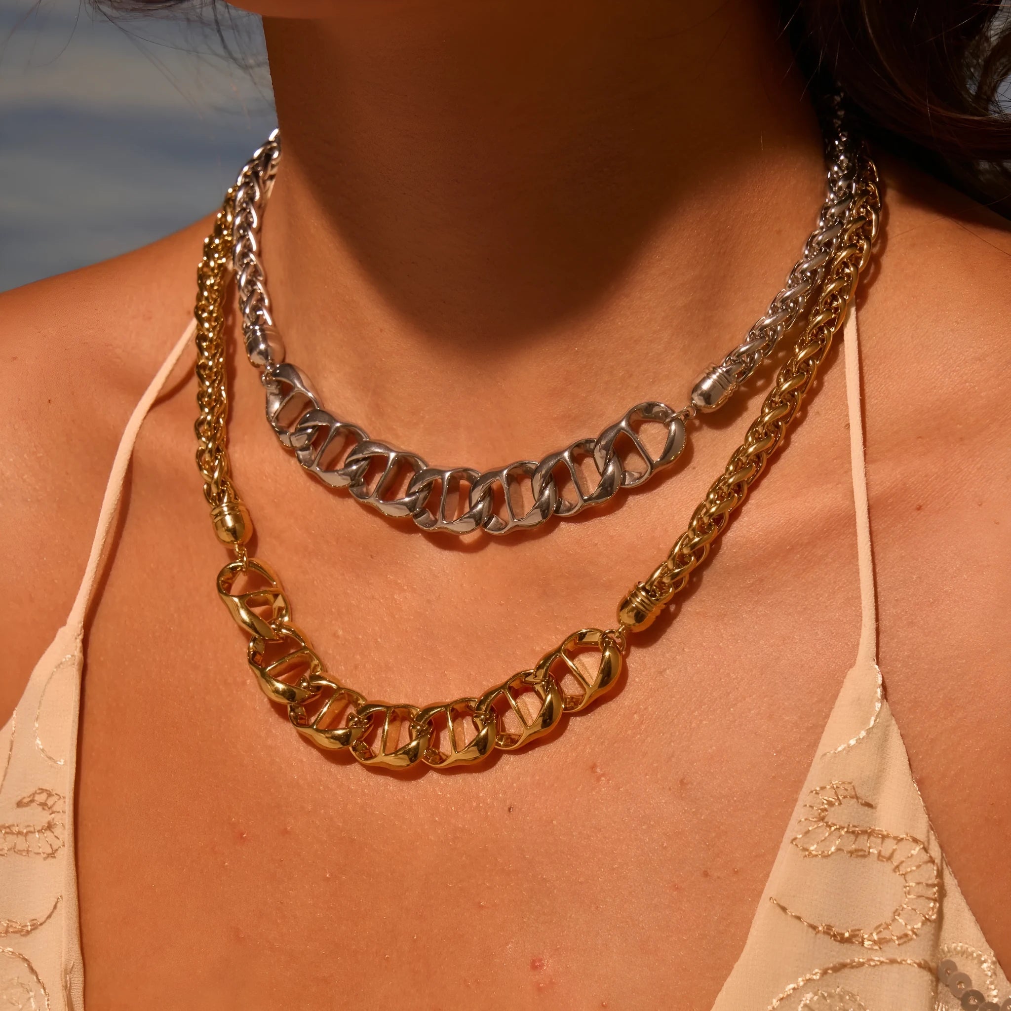 Gold plated stainless steel geometric chain necklace for women on a white background.