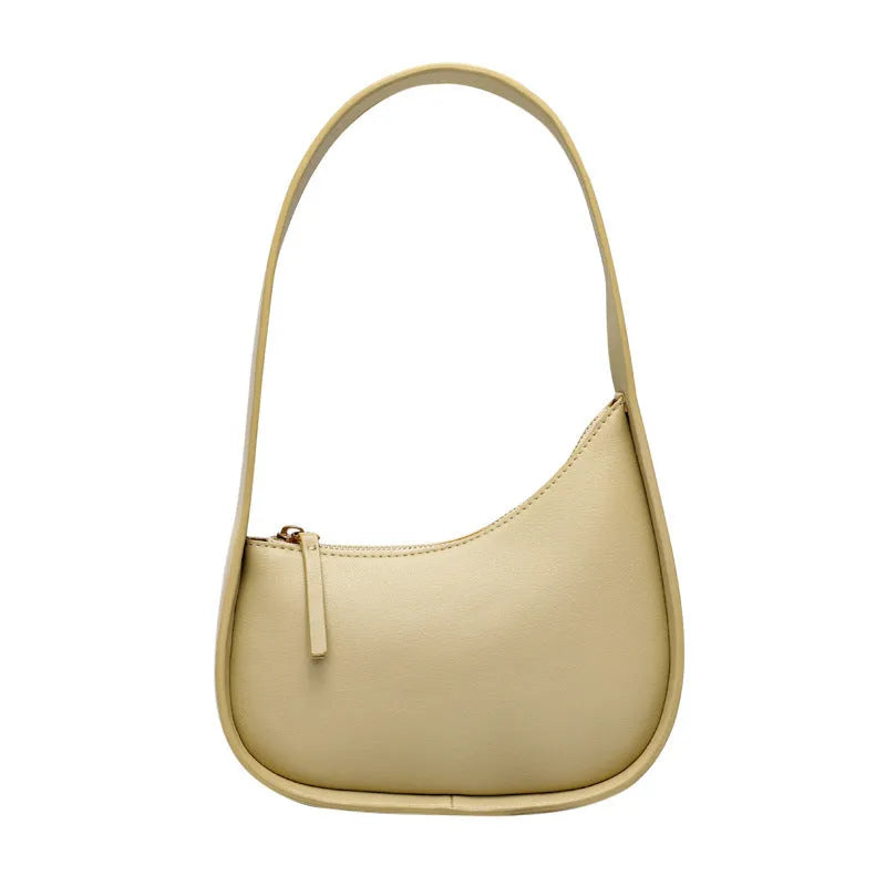 Women's half moon shaped leather shoulder bag in light brown with an adjustable wide strap.