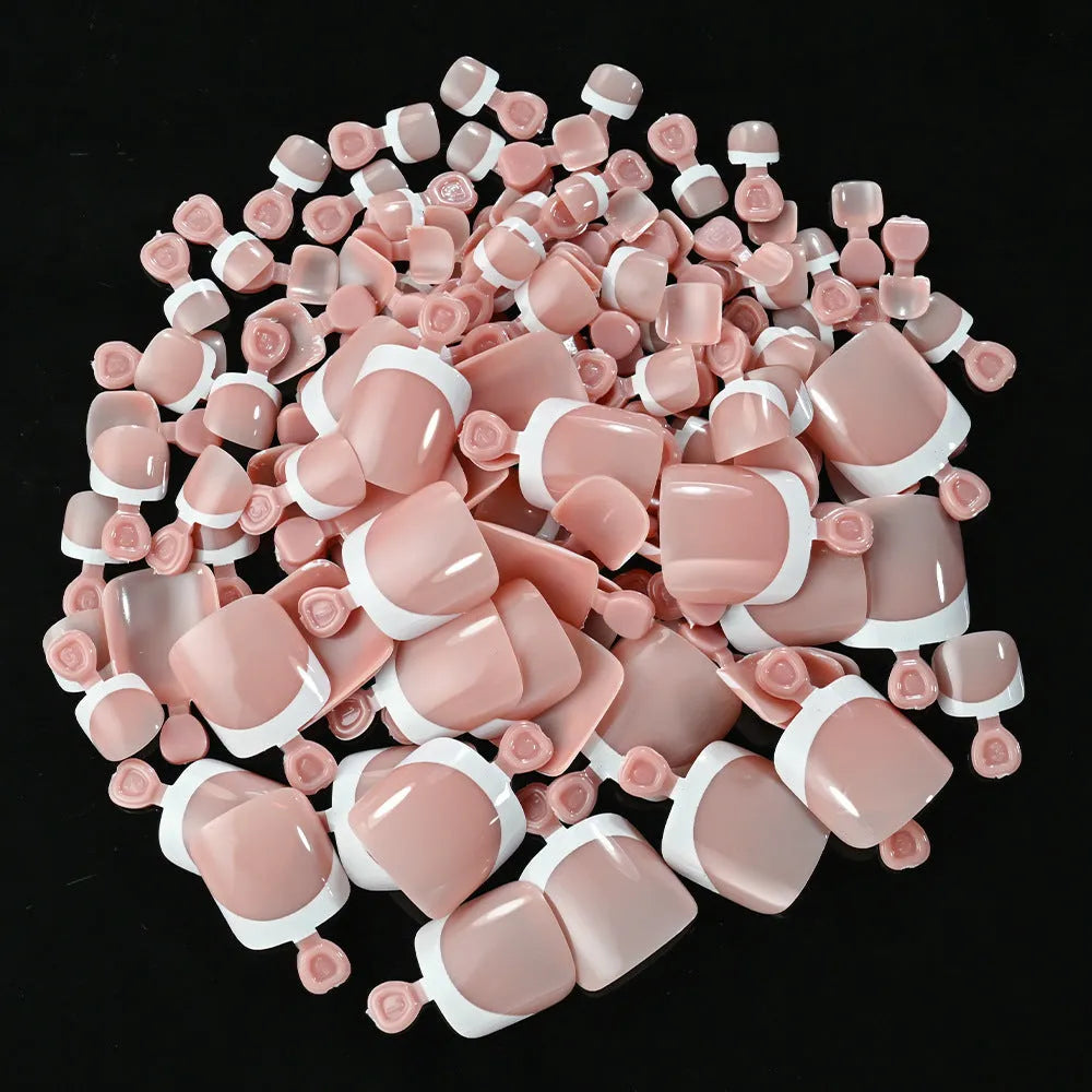Box of 120 French white edge nude false toe nail pieces in assorted shades on a table