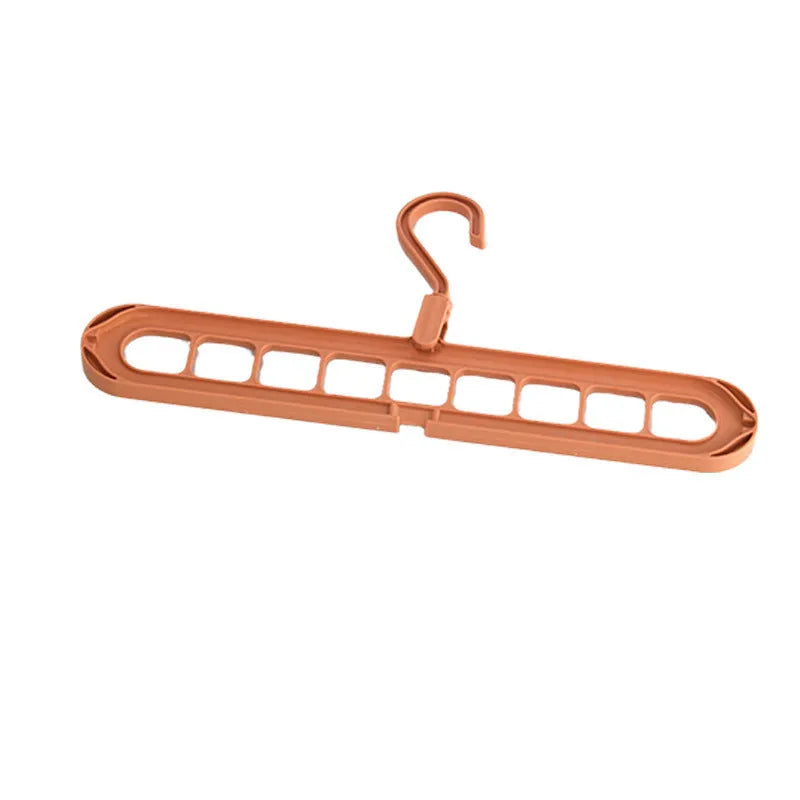 Green plastic nine-hole folding hanger for trousers shown in a dormitory wardrobe.