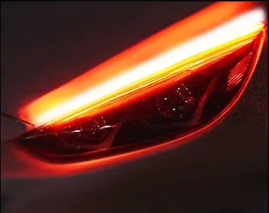 Flexible silicone car LED daytime running light strip with flowing turn signal animation mounted on headlight.