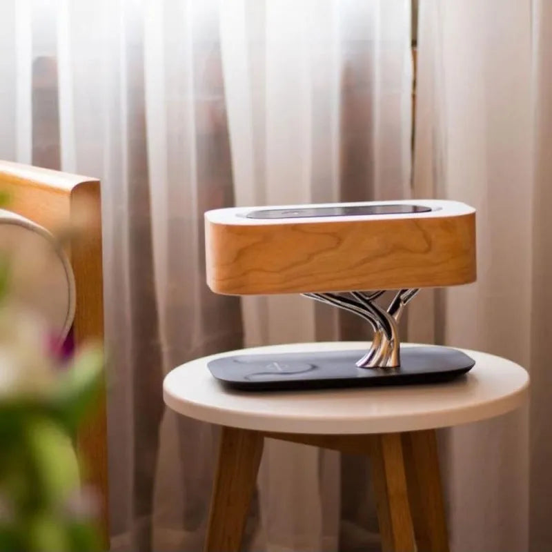 Creative tree light table lamp with natural cherry veneer shade, Bluetooth speaker, and wireless charging on a bedside table