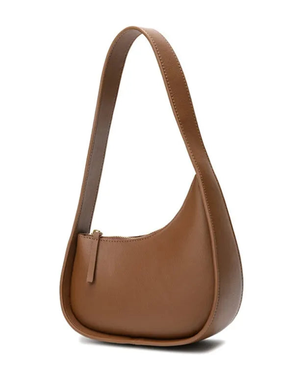Women's half moon shaped leather shoulder bag in light brown with an adjustable wide strap.