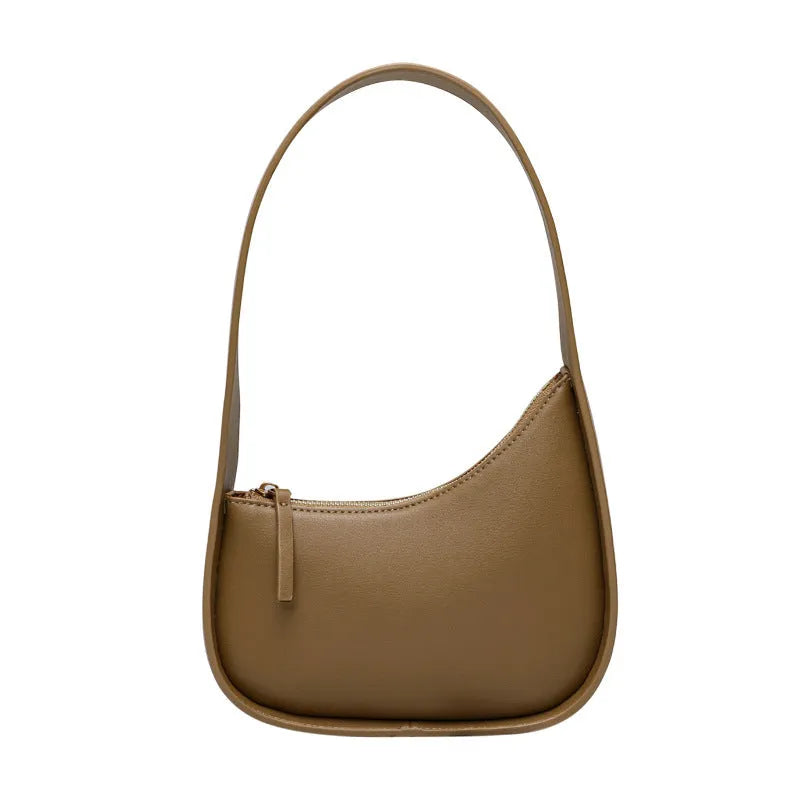 Women's half moon shaped leather shoulder bag in light brown with an adjustable wide strap.