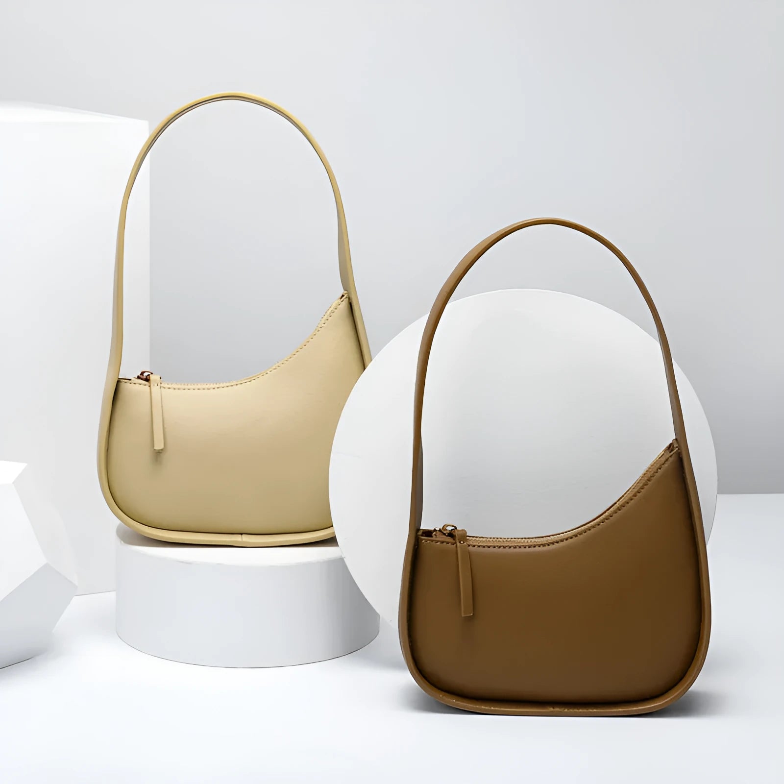 Women's half moon shaped leather shoulder bag in light brown with an adjustable wide strap.