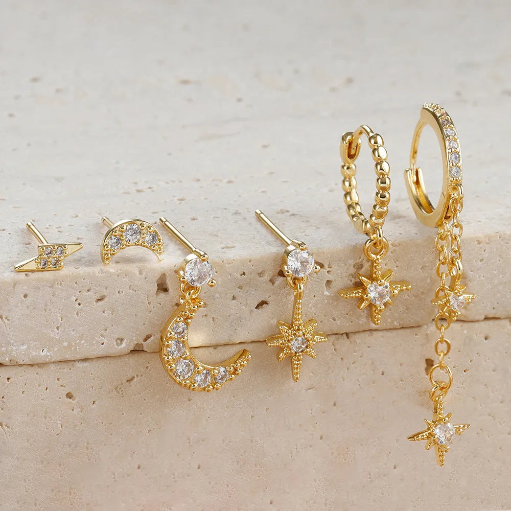 Six pairs of gold electroplated earrings with chain tassel and zircon stud designs representing different months