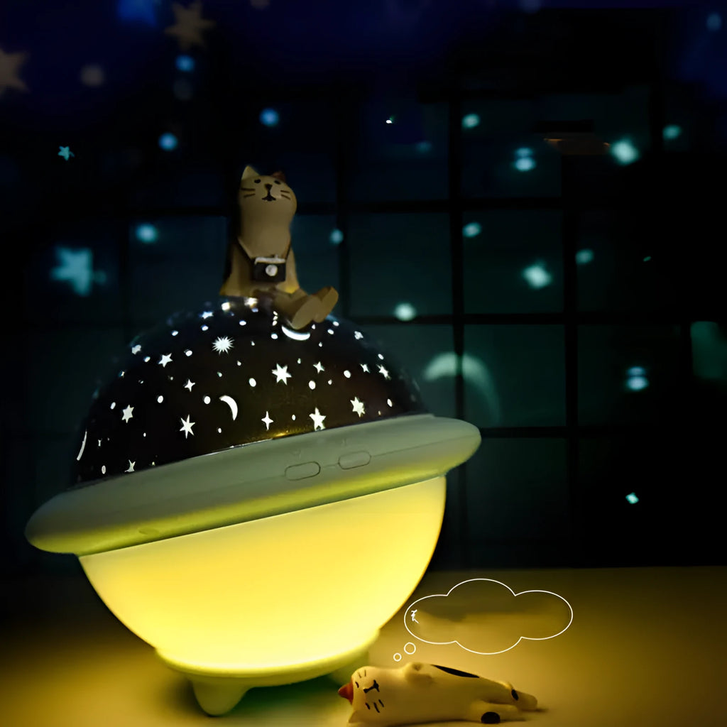 UFO-shaped plastic starry sky projection night light in pink on a wooden surface