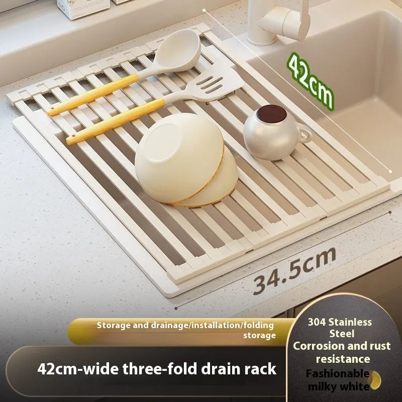A milky white foldable stainless steel kitchen draining rack shown open on a countertop next to a sink.