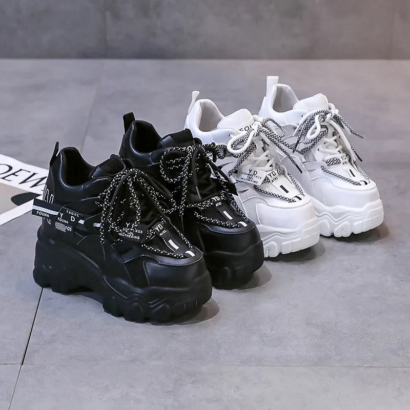 Women's white and black mesh platform tennis shoes with cross strap and thick rubber sole.