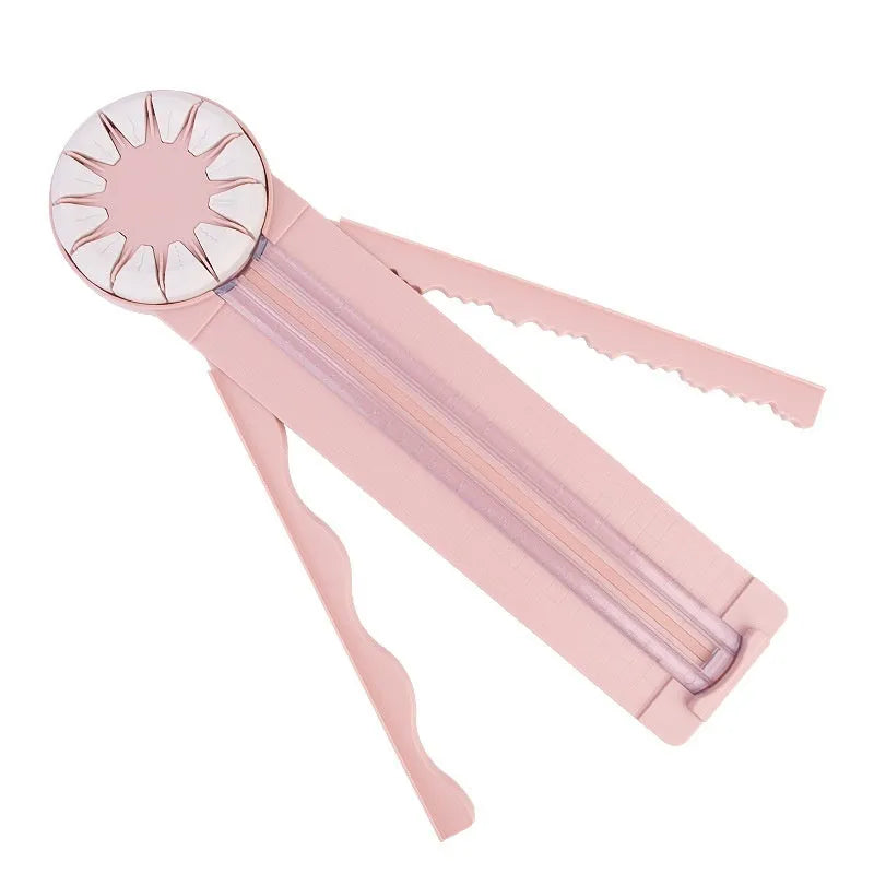 Pink plastic 12-in-1 multifunctional paper cutter with dotted guide lines on a white surface.