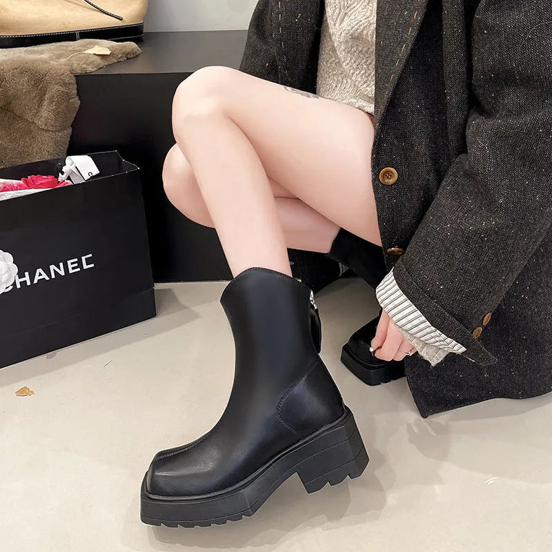 Women's black platform Martin ankle boots with a square toe, chunky sole, and back zipper.