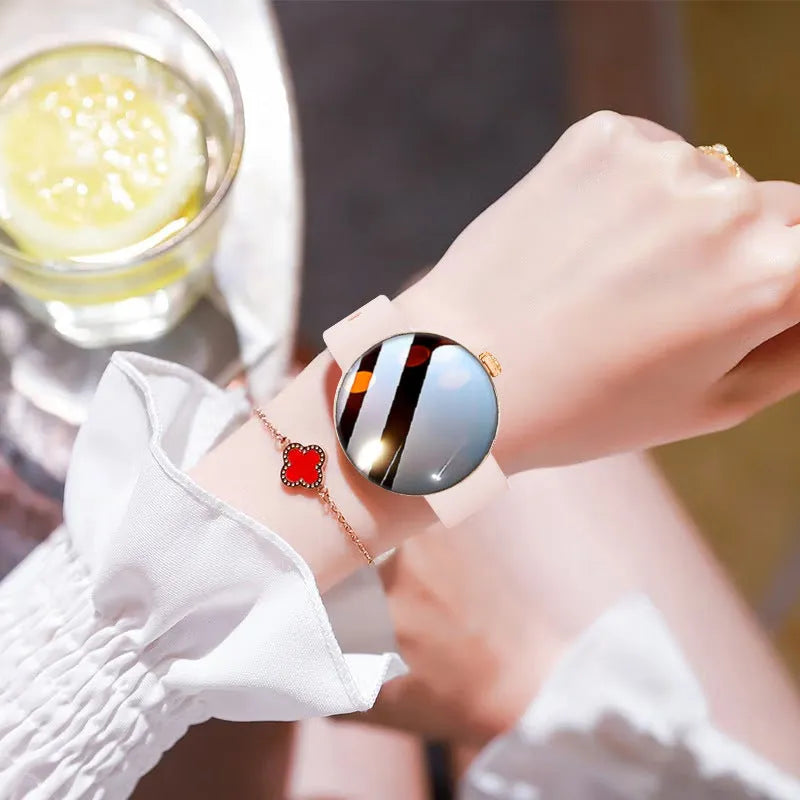Women's smart watch with circular colour screen and metal strap on a wrist.