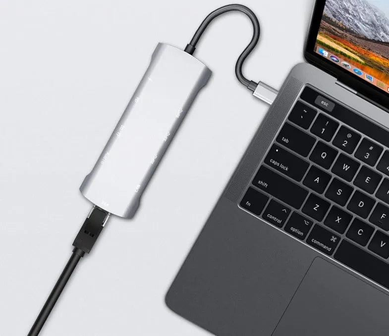 Grey aluminium USB-C docking station with HDMI, VGA, USB ports and a short connecting cable