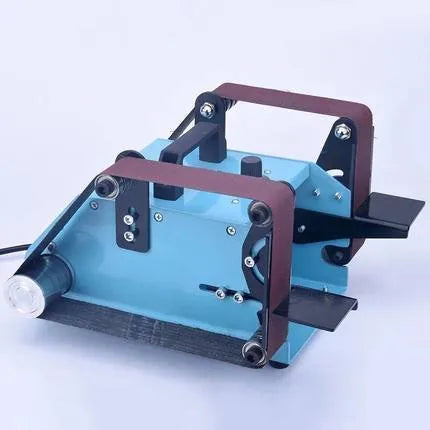 Blue desktop dual-axis belt sander with abrasive belt, shown on a workshop bench.