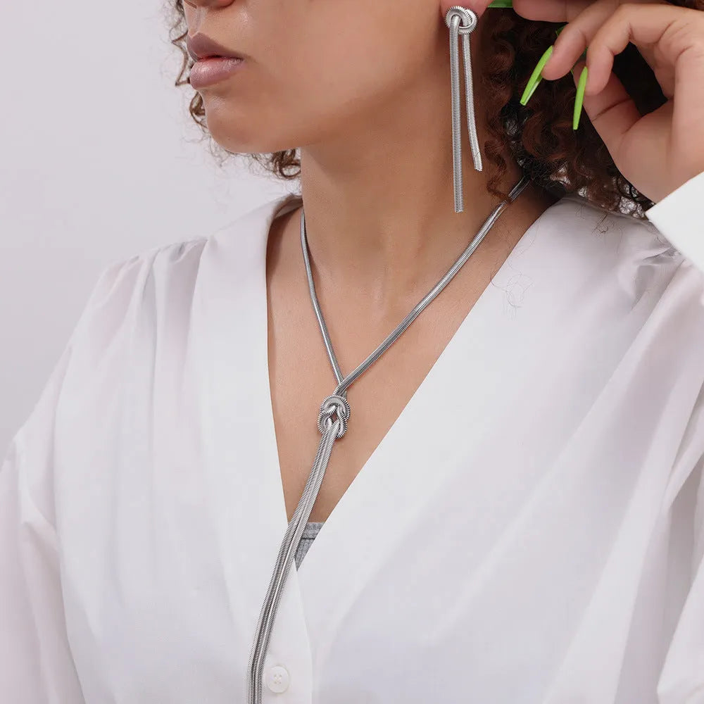 Gold colour knotted tassel pendant on a snake chain necklace with matching electroplated earrings.