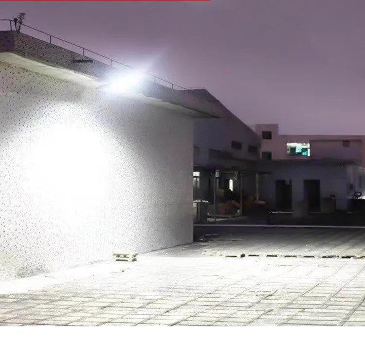 Black solar-powered outdoor motion sensor light mounted on a wall or post.