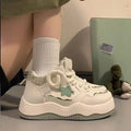 Green women's platform sneakers with patent leather finish, round toe, and white rubber sole.