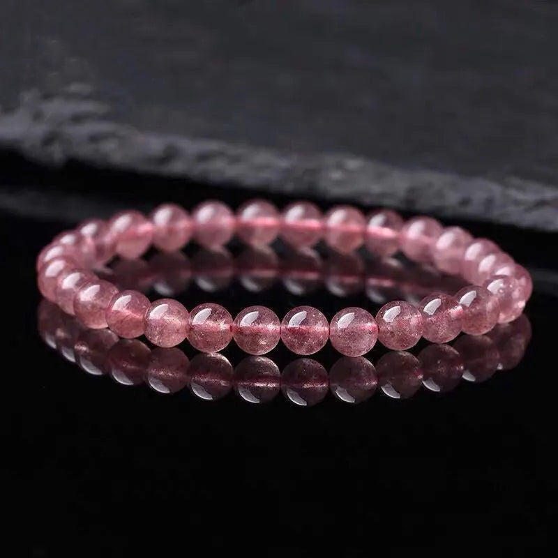 Women's bracelet with round, polished strawberry quartz crystal stones in natural pink tones.