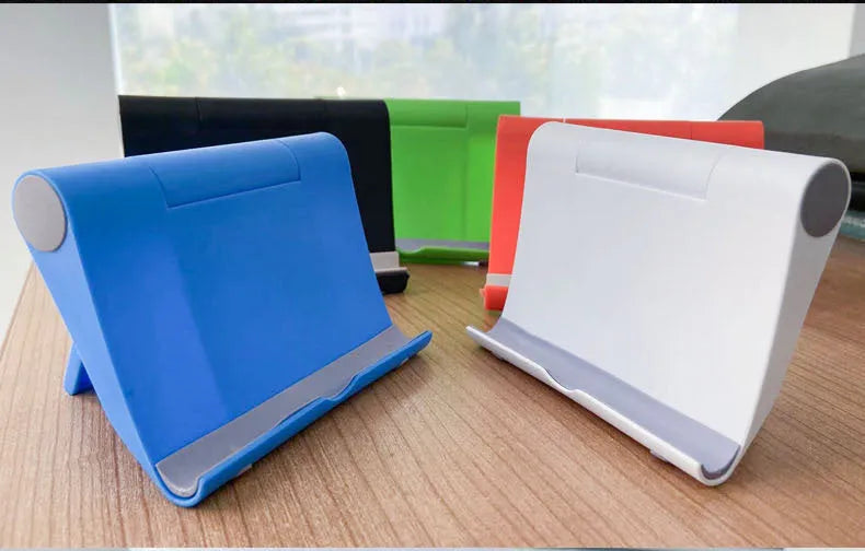 Black folding mobile phone and tablet stand with multi-angle adjustment on wooden table
