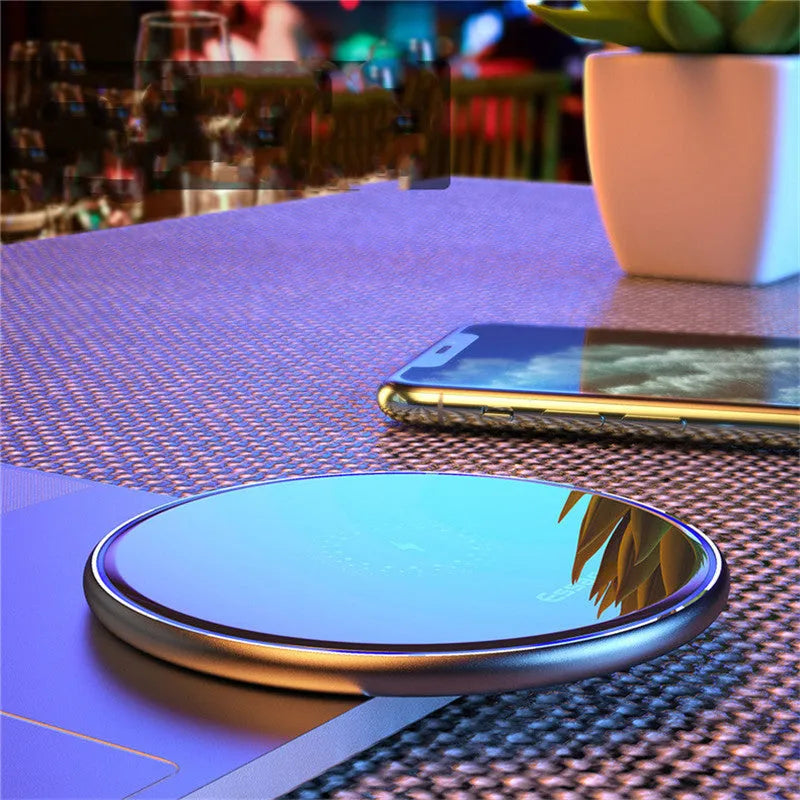 Black or white aluminium alloy 15W Qi wireless charging pad with LED light on a desk.
