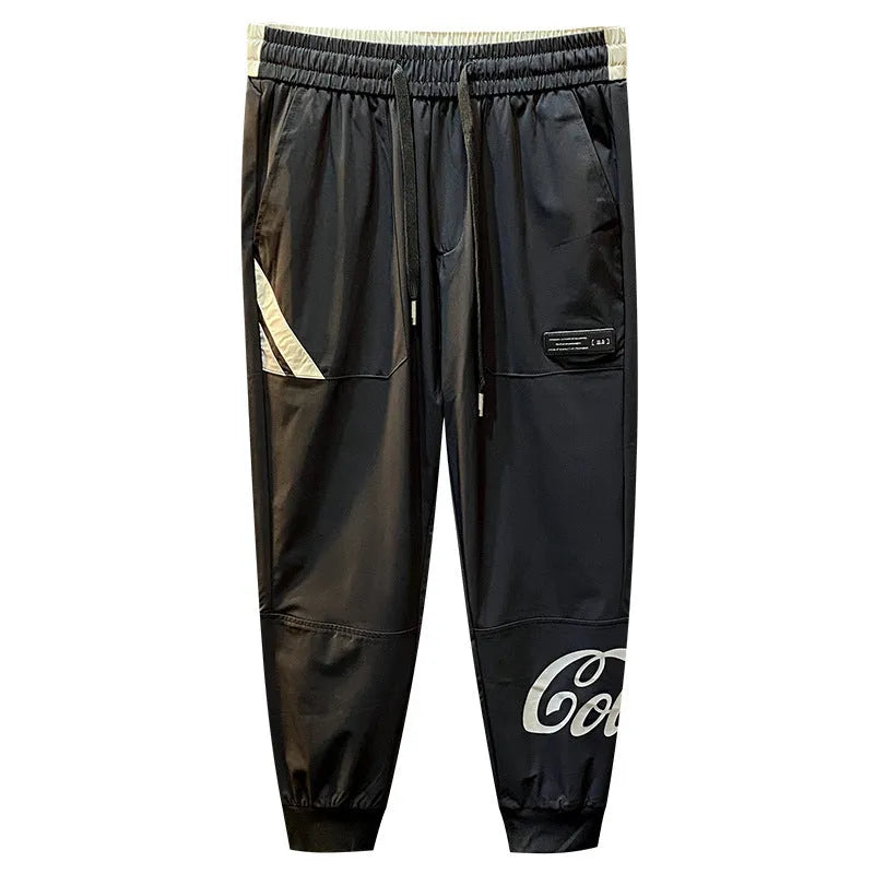 Men's solid black cotton cropped trousers with elasticated ankle band cuffs laid flat.
