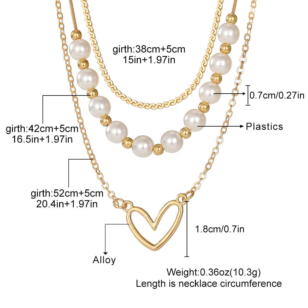 Vintage gold heart pearl necklace with adjustable chain on white background