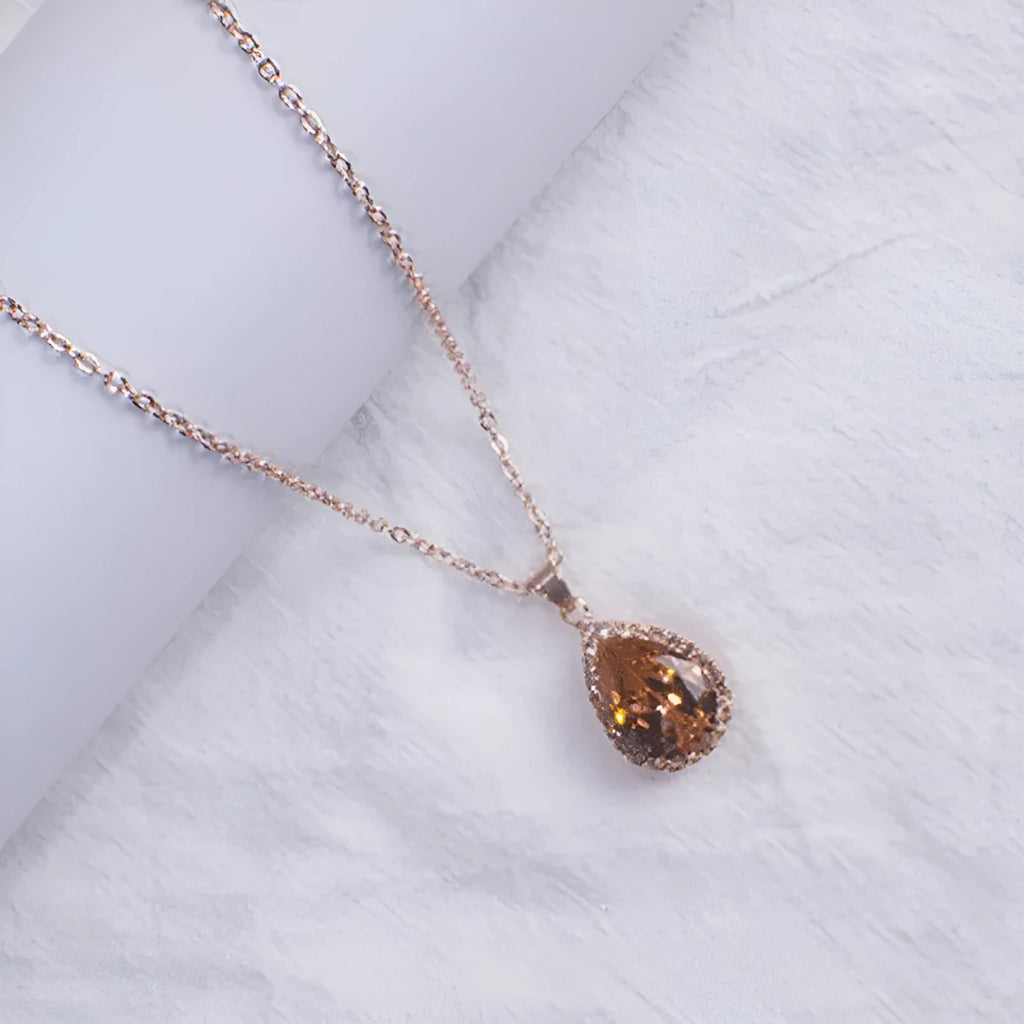 Rose gold water drop shape necklace with rhinestone geometric detailing in pink colour