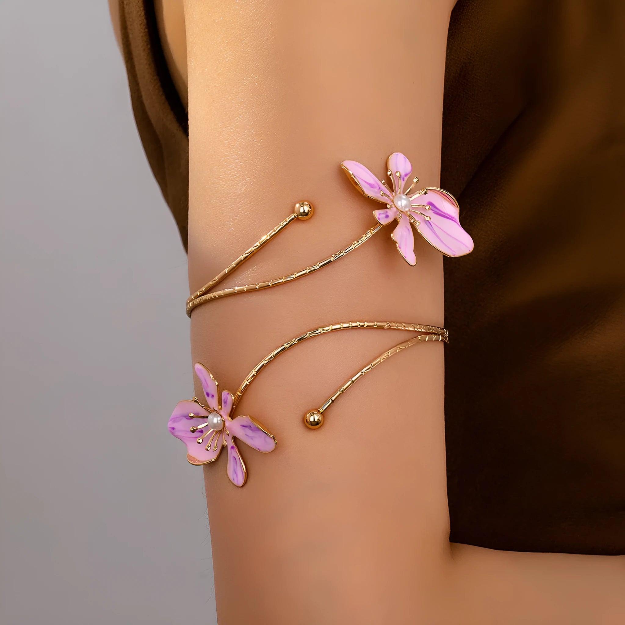 Pink alloy fashion armband with a hollow, openwork pattern shown on a wrist.