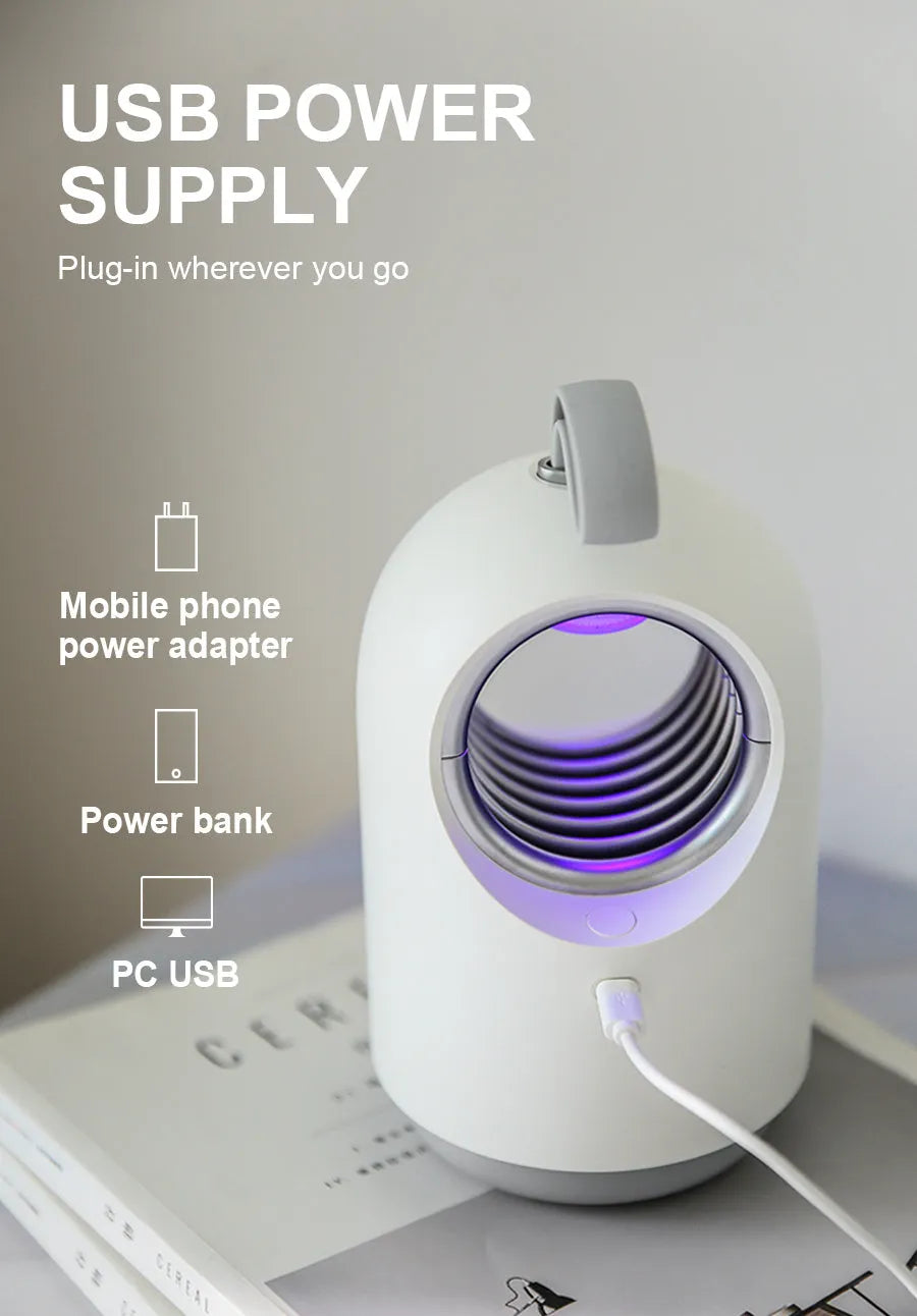 White indoor mosquito killer lamp with blue UV light and a top carry handle on a table