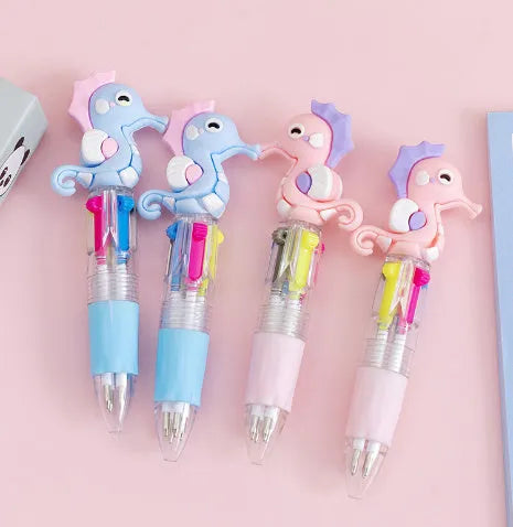 A cartoon-themed press-type ballpoint pen showing four-colour cartridge and a random print design on a silicone and plastic barrel.
