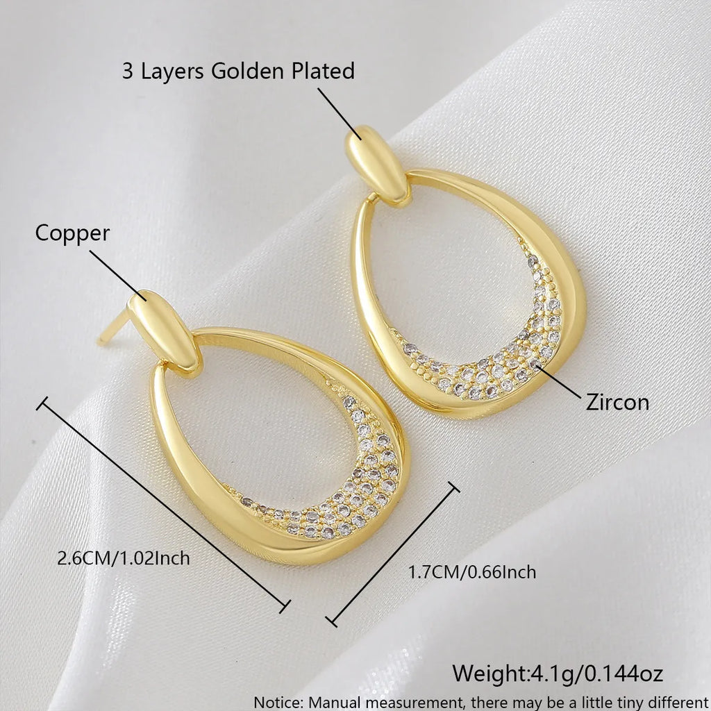 Yellow gold geometric drop earrings with oval and round ring elements on copper