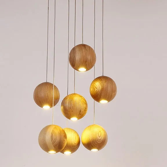 Nordic style solid wood ball chandelier with wooden spheres hanging from a wood disc ceiling plate.