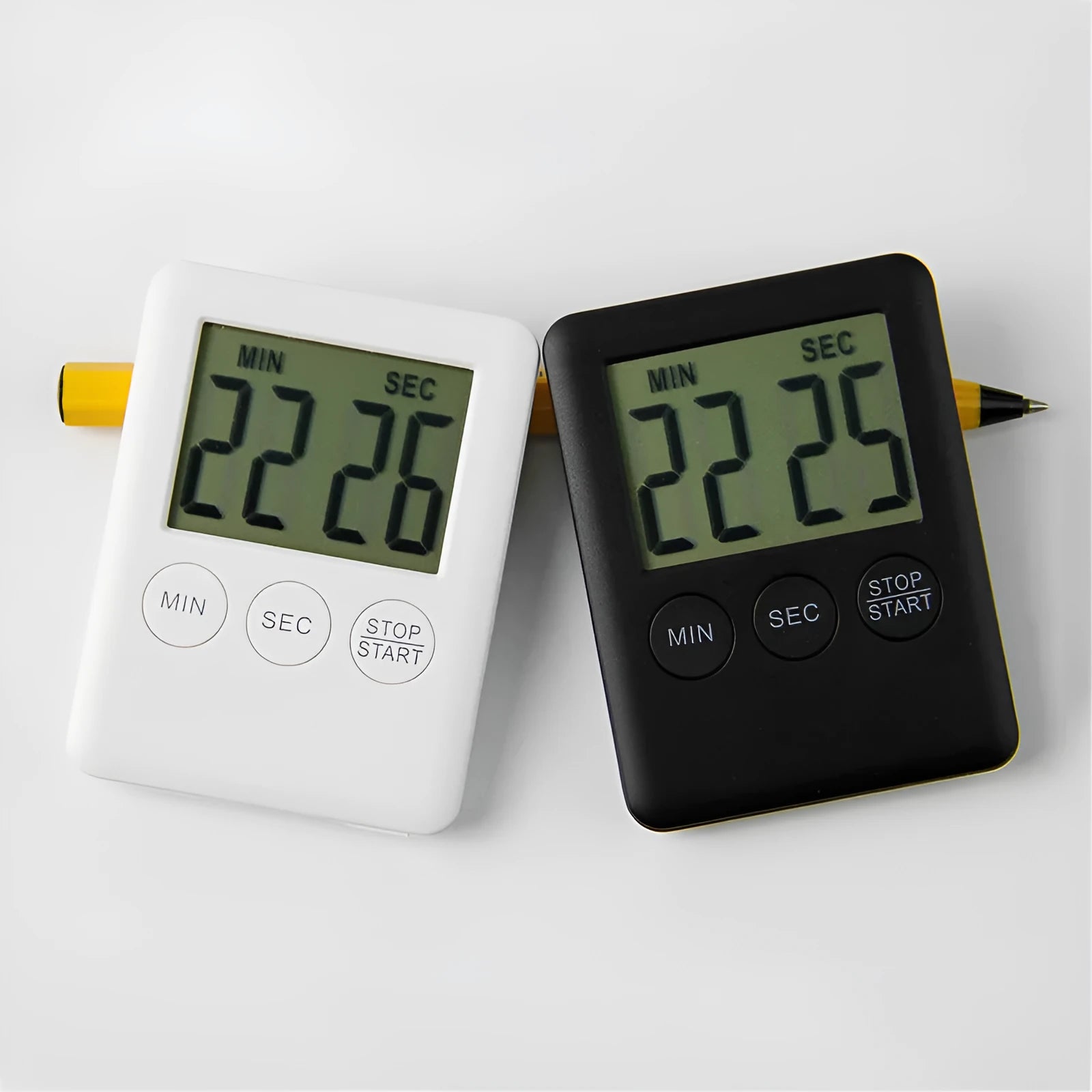 Black and white magnetic kitchen timer with large digital display on a refrigerator.