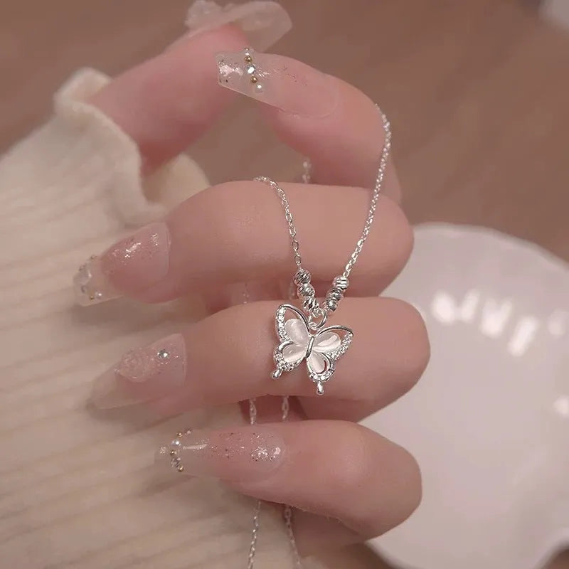 Silver butterfly necklace with opal accents on adjustable cross chain