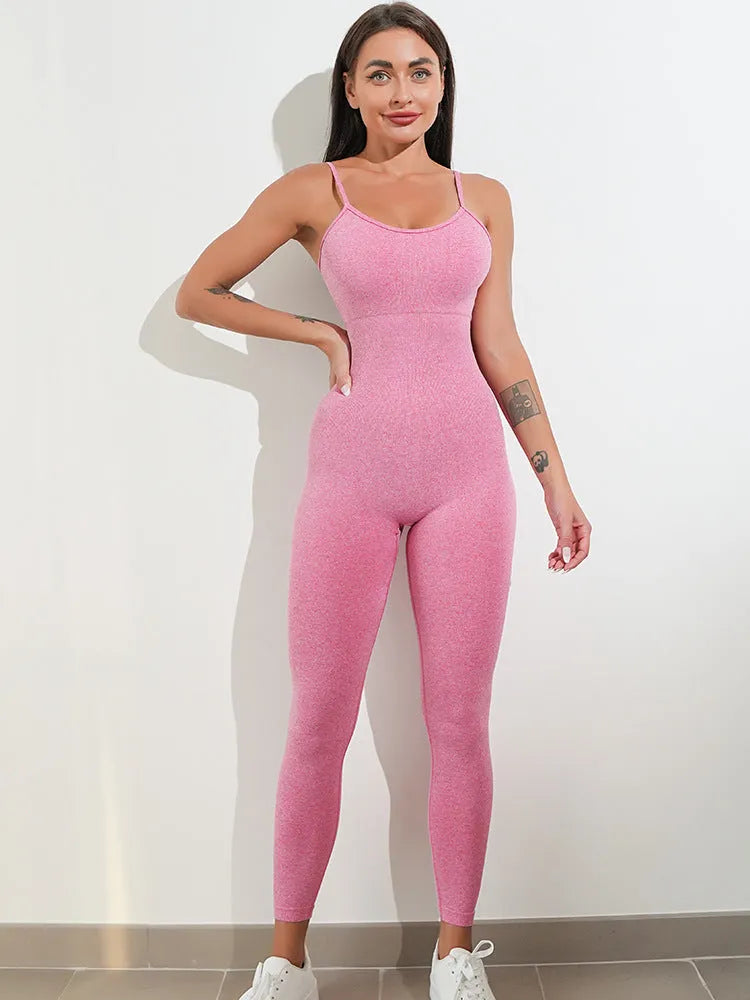 Woman wearing a black sleeveless unitard jumpsuit with spaghetti straps, showcasing the form-fitting tummy control design.