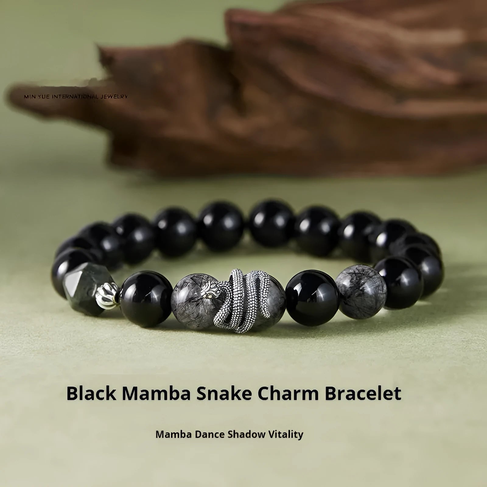 Men's obsidian black snake bracelet made of sterling silver with retro zodiac styling on a wrist.