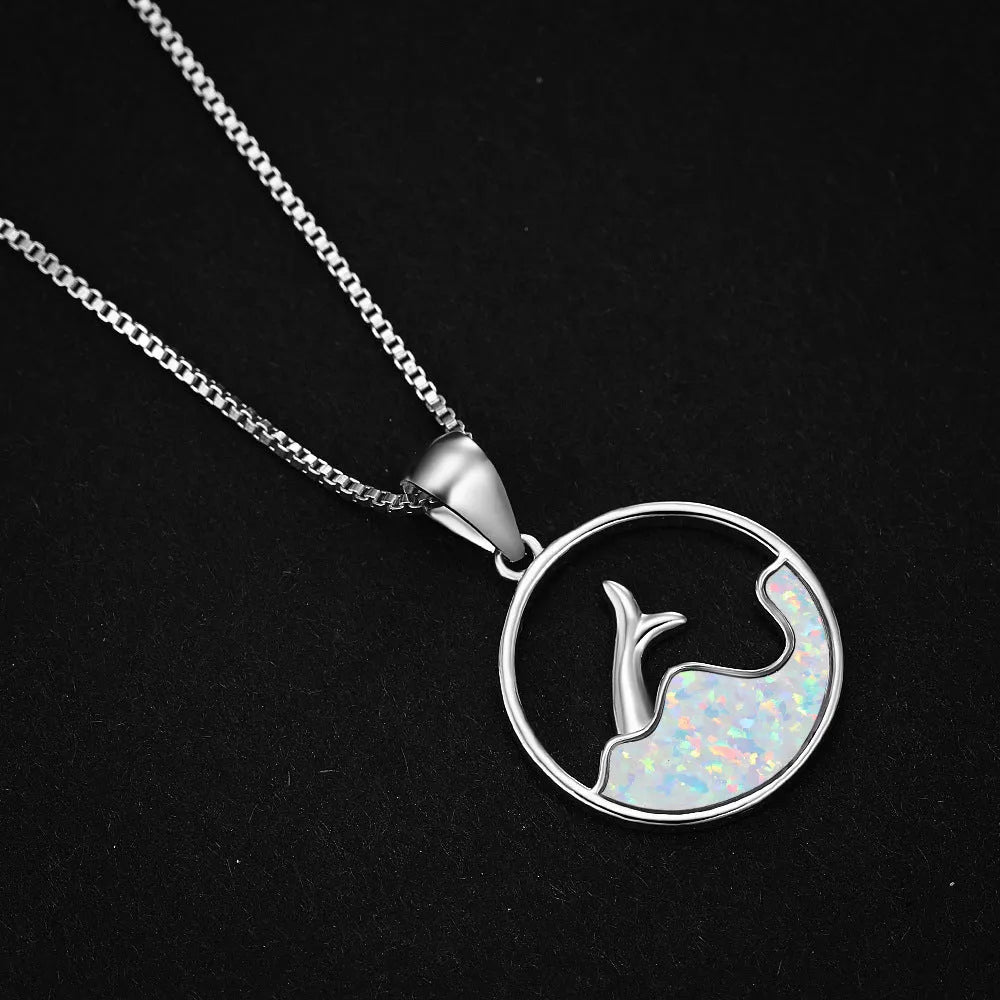 White gold geometric fishtail necklace with a round blue opal pendant on an adjustable chain.