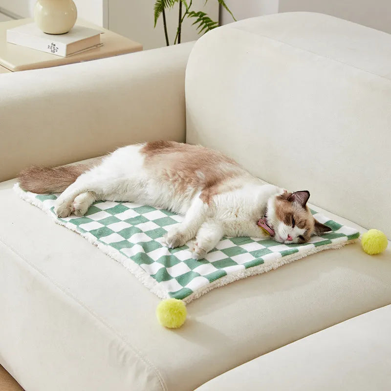 Plush cotton fleece pet blanket with plaid pattern and fur balls in green colour on couch