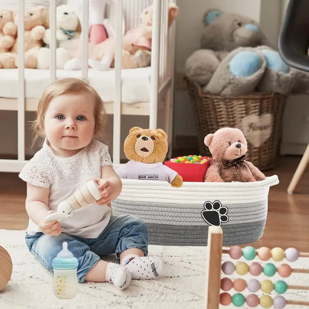 Light beige handmade cotton rope storage basket with handle, shown with toys inside.